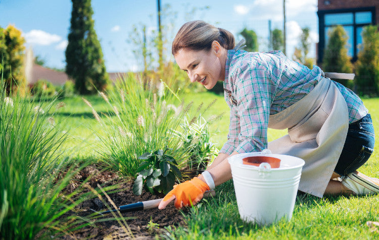Woman kneeling and working in her garden