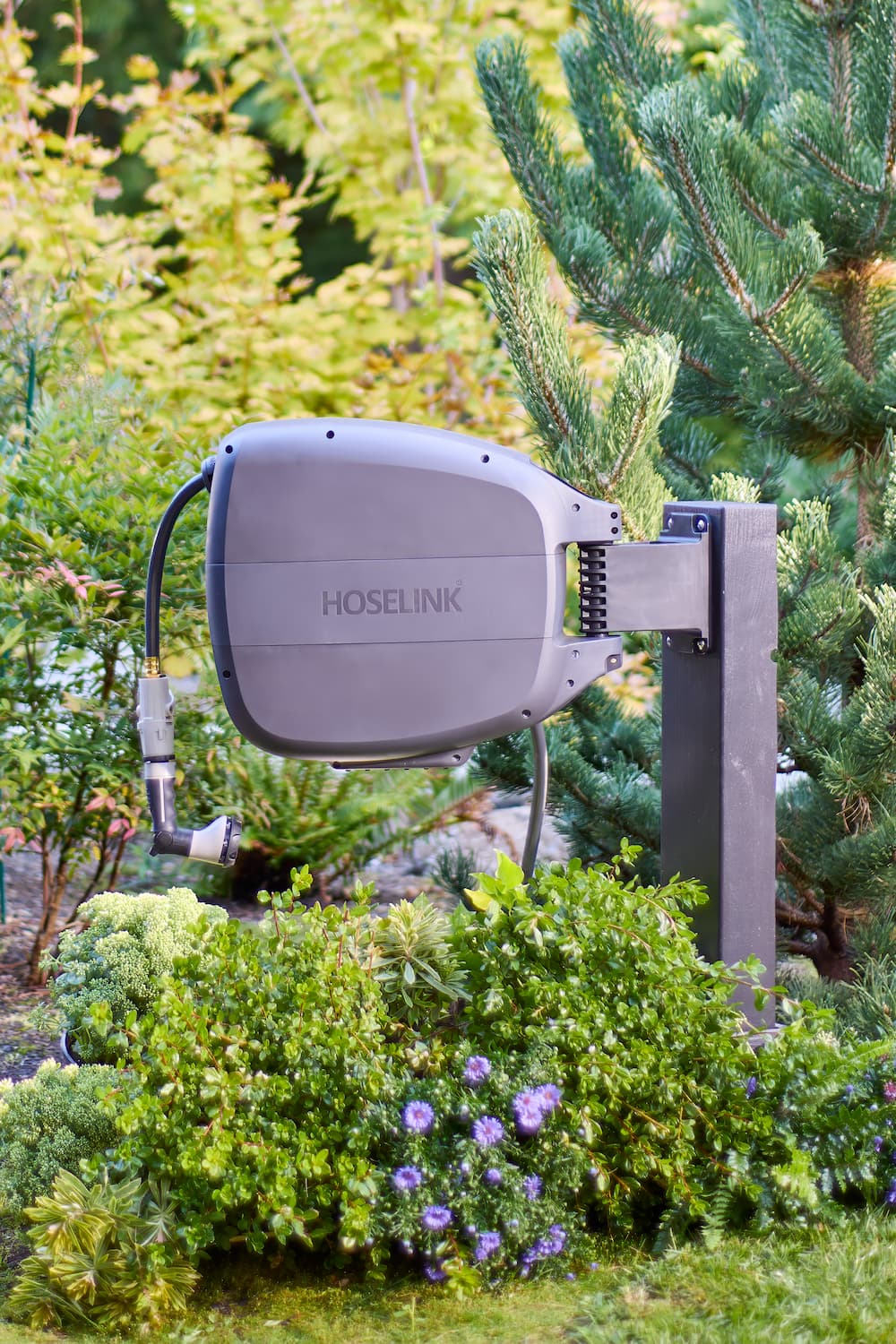 beige-retractable-hose-reel-mounted-to-a-fence