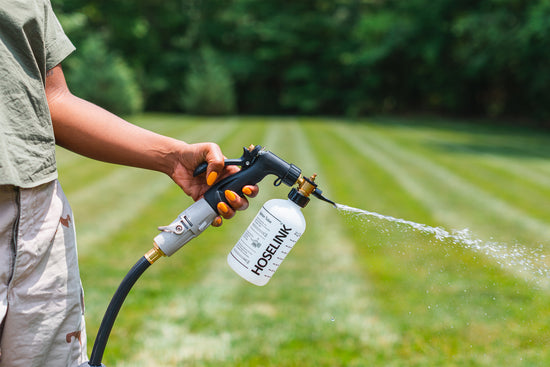 person-holding-a-Hoselink-Fertlizer-Spray-bottle-in-their-hand-with-water-spraying-out