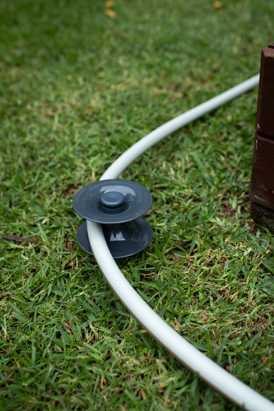 ground hose guide in the lawn with hose running through it