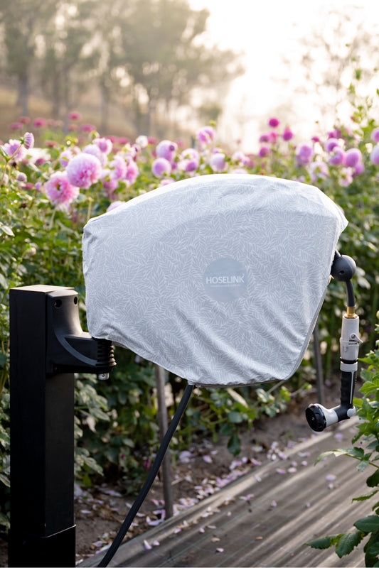 Retractable Hose Reel mounted in a garden with a hose reel cover on it