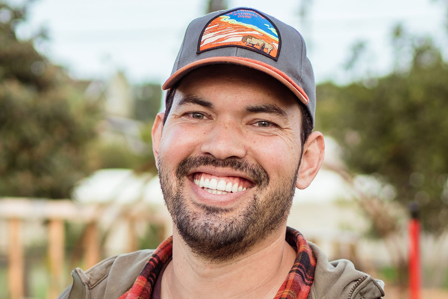 Kevin Espiritu smiling in garden wearing baseball cap