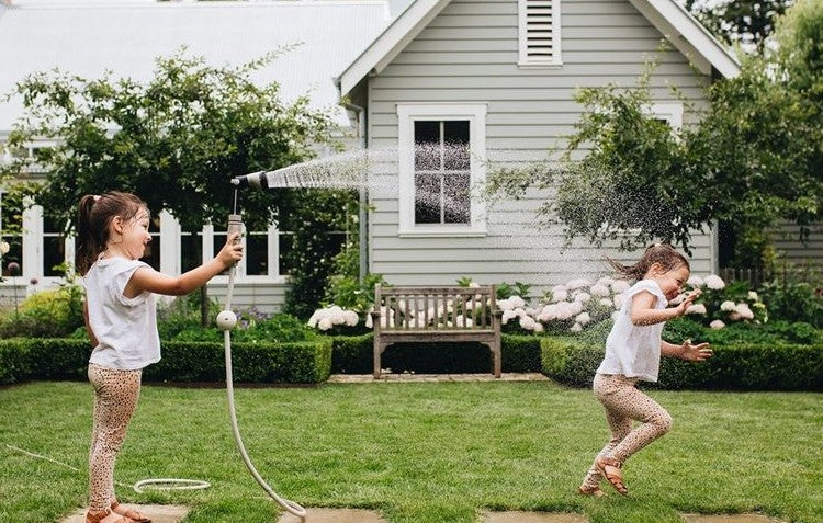 Girls spraying water in the backyard