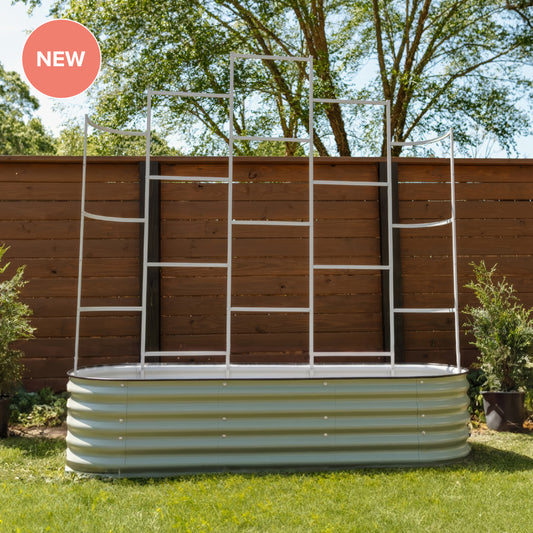 A corrugated metal garden bed with a white metal ladder-style trellis frame set up outdoors on grass in front of a wooden fence. A pink circular 'NEW' badge appears in the top-left corner.