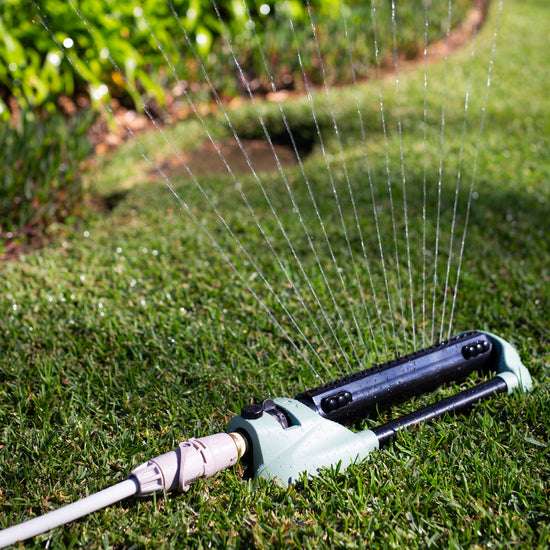 Green Oscillating Sprinkler watering lawn connected to hose using Hoselink quick connects