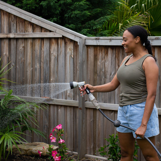 female watering garden plants using the 7 function spray gun