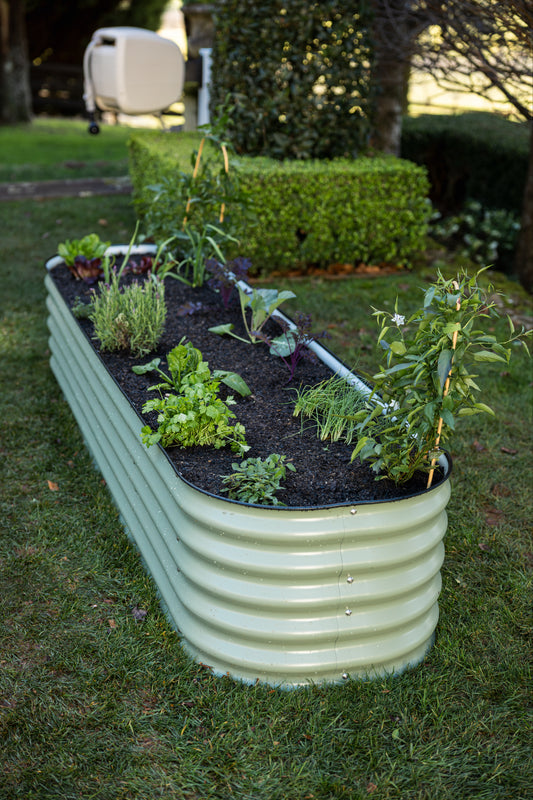 9 in 1 garden bed in long narrow formation on grass with Evolve hosereel in the background.
