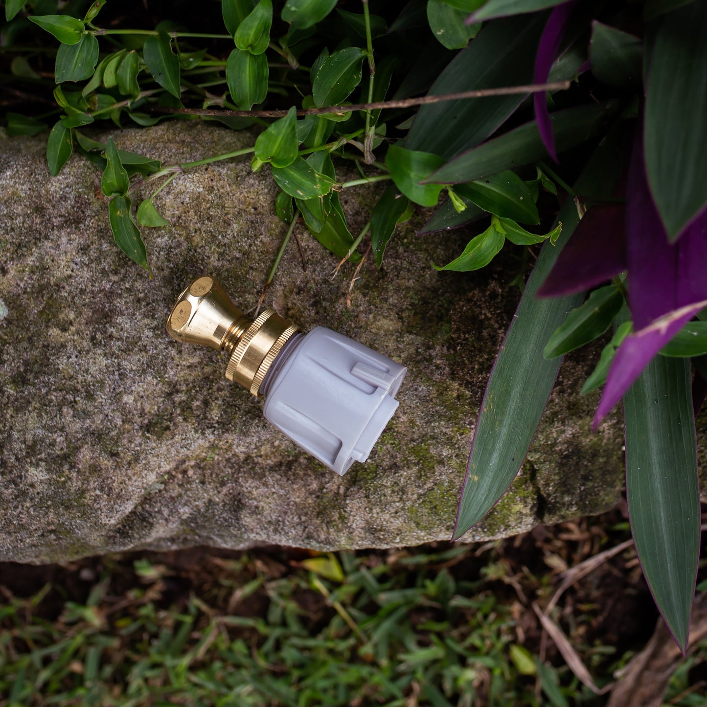 Brass high pressure jet nozzle on a concrete wall in the garden