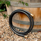 Charcoal colour leader hose coiled and leaning against planter