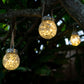 Three solar crackle jar lights hanging from a tree