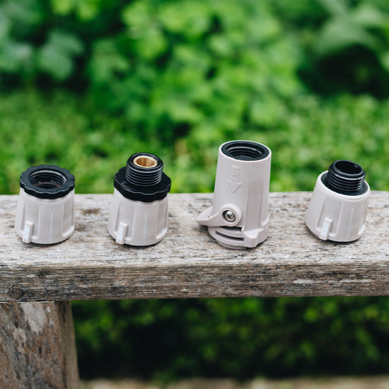 US Warm Gray Hose Connectors lined up on arm of bench in garden