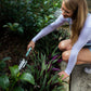 Woman gardening in a backyard using the Garden Trowel