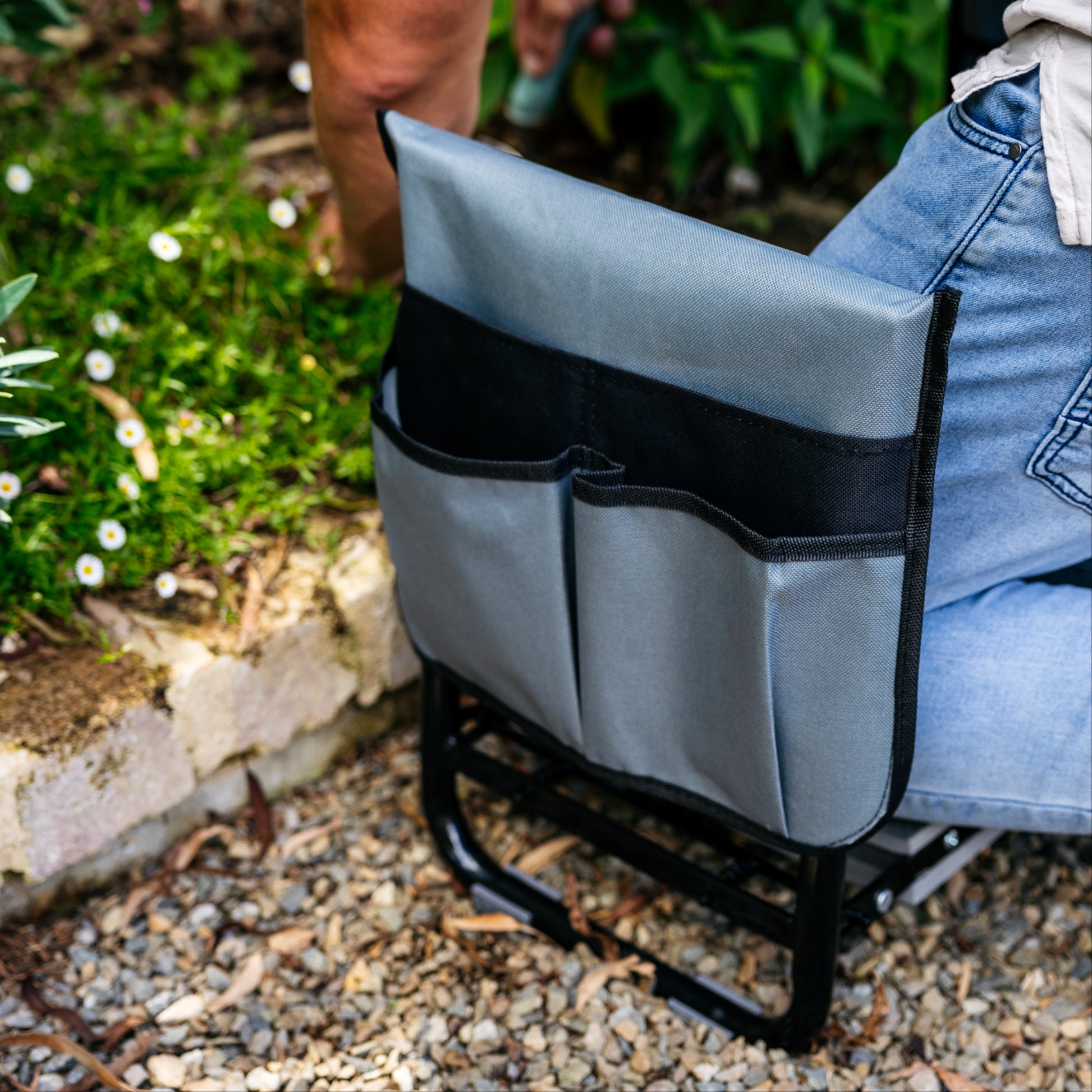 Close up of charcoal and black colored tool pouch on side of garden kneeler and seat 