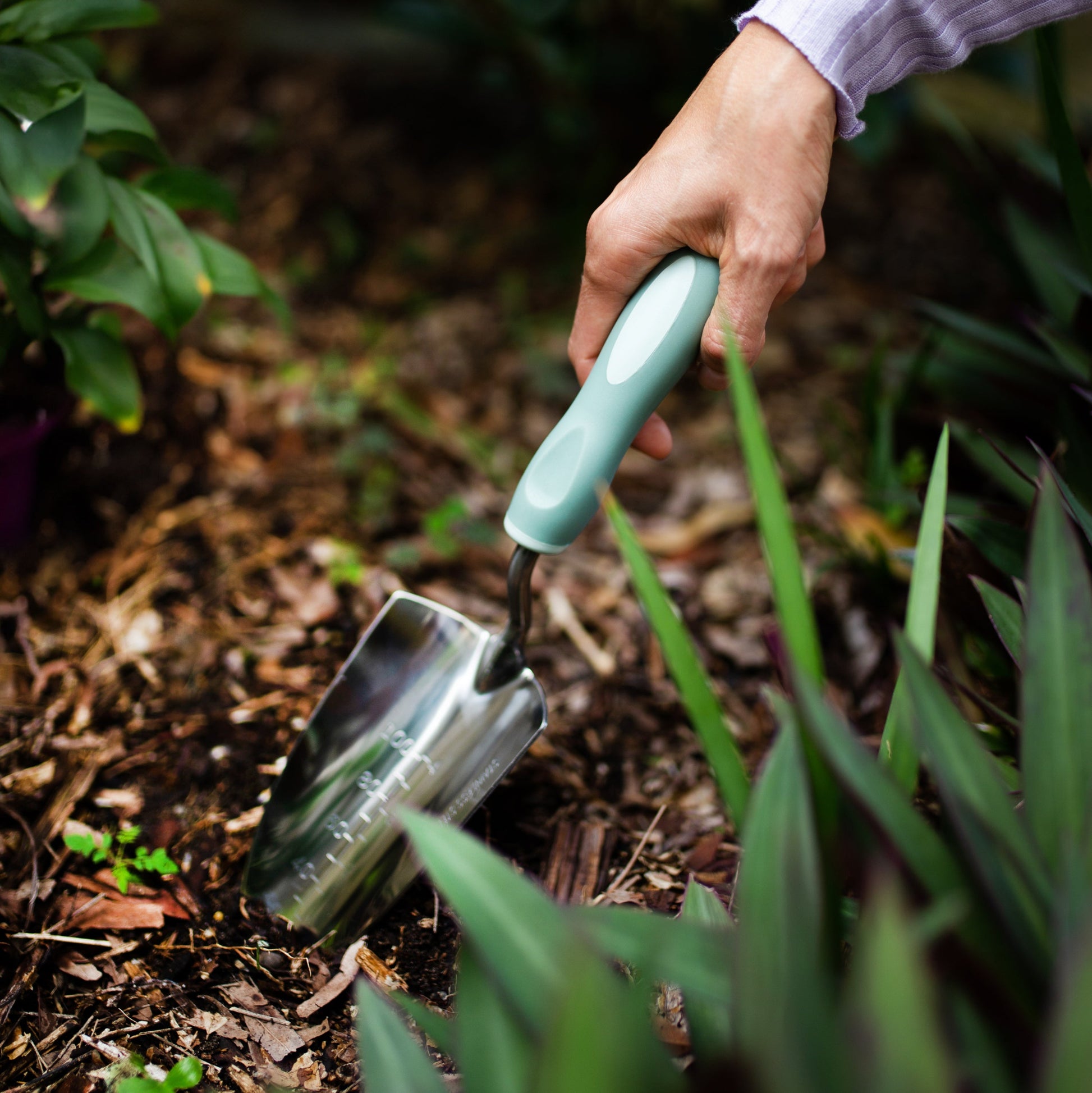 Hand using the Garden Trowel in a garden setting