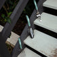 Gardening tools with green handles on a set of outdoor stairs.