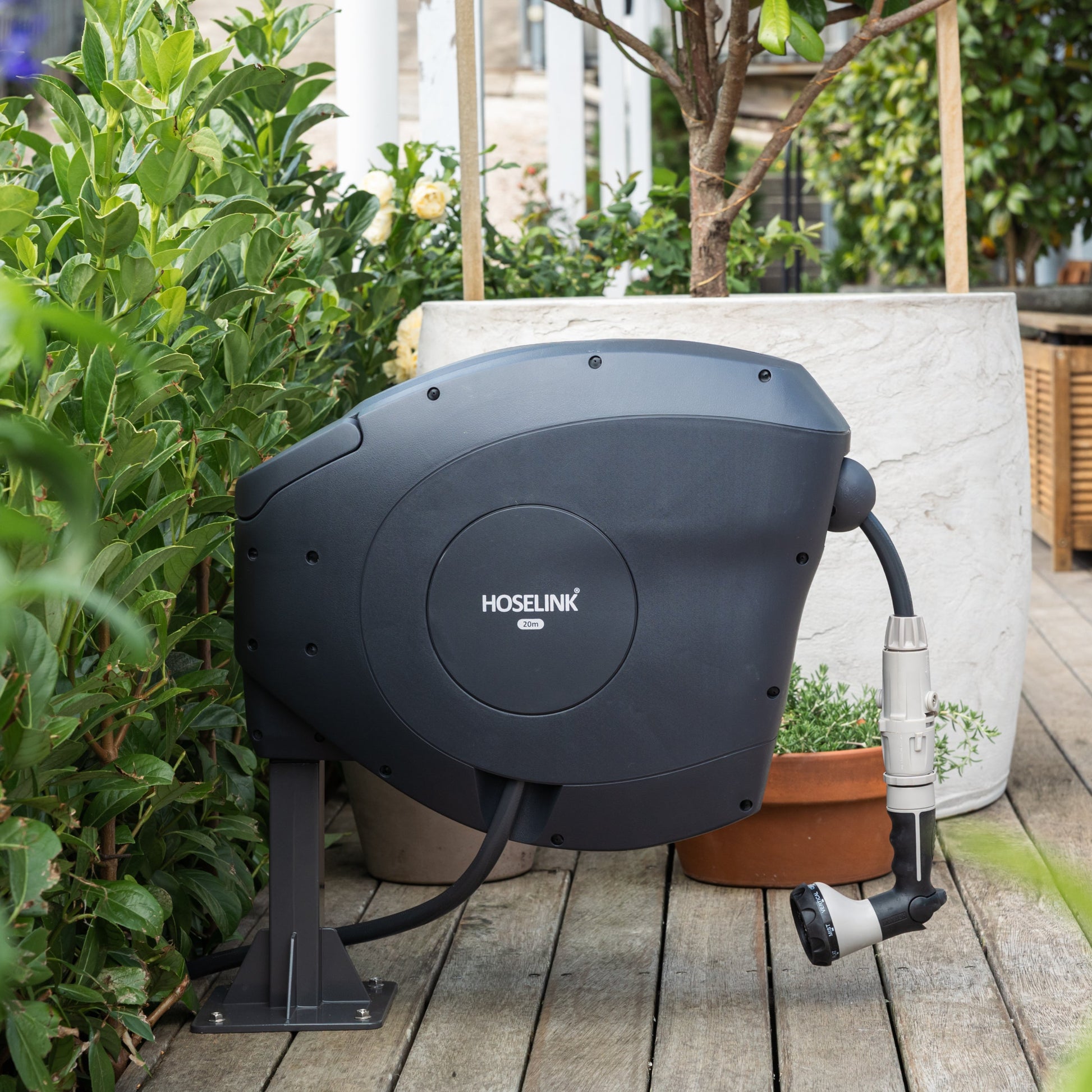 Black hose reel on a wooden deck with the Ground Mount Classic Series