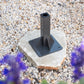 Ground Mount Classic series on a stone base with purple flowers in the foreground