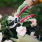 person wearing bamboo gloves cutting pink roses with pink secateurs