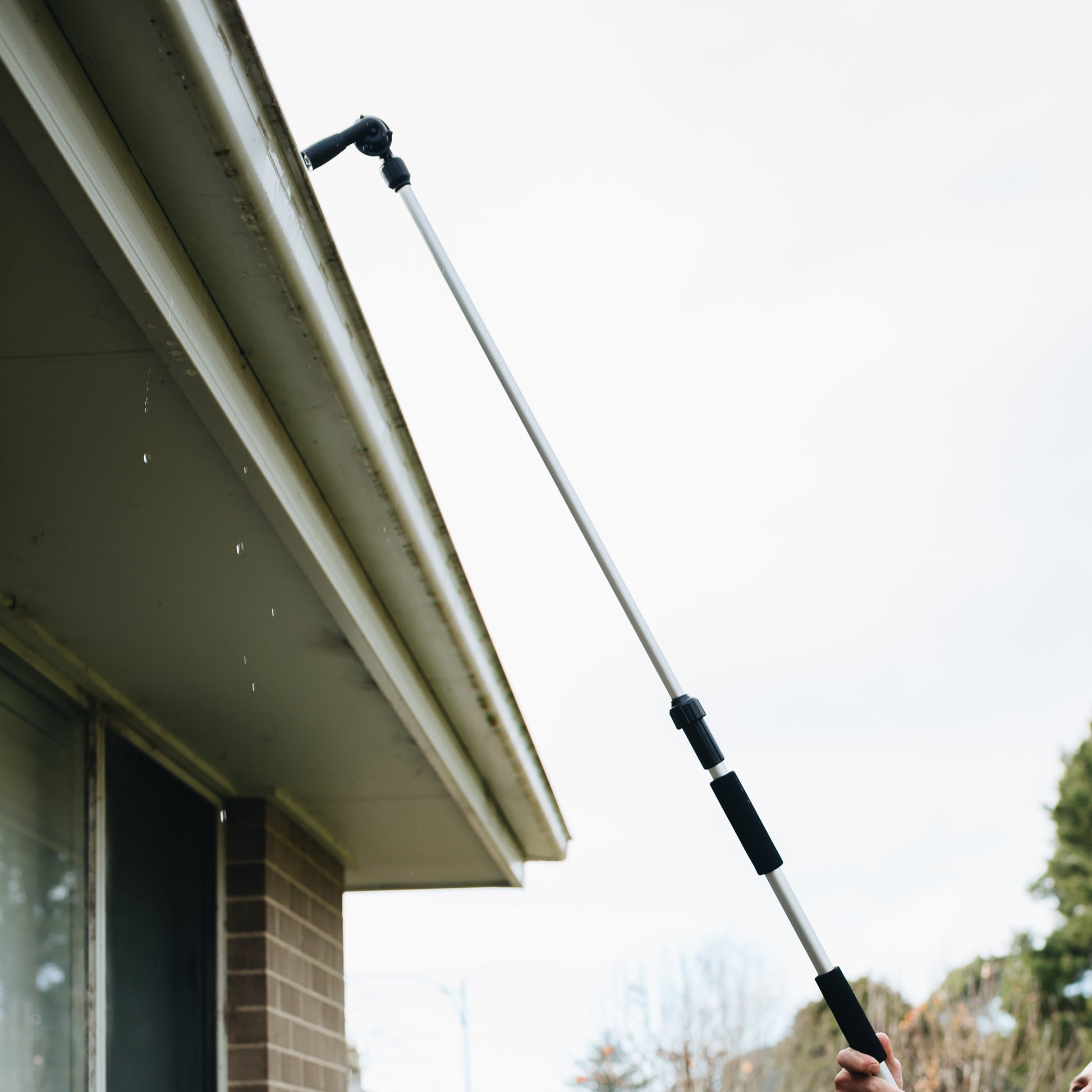 long-reach pivot gutter cleaner reaching into gutter