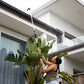 woman cleaning gutter with long-reach pivot gutter cleaner