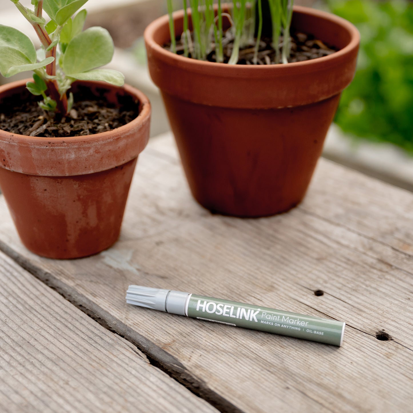 Close up of Hoselink's Permanent Marker Pen with plants in pots at the background.