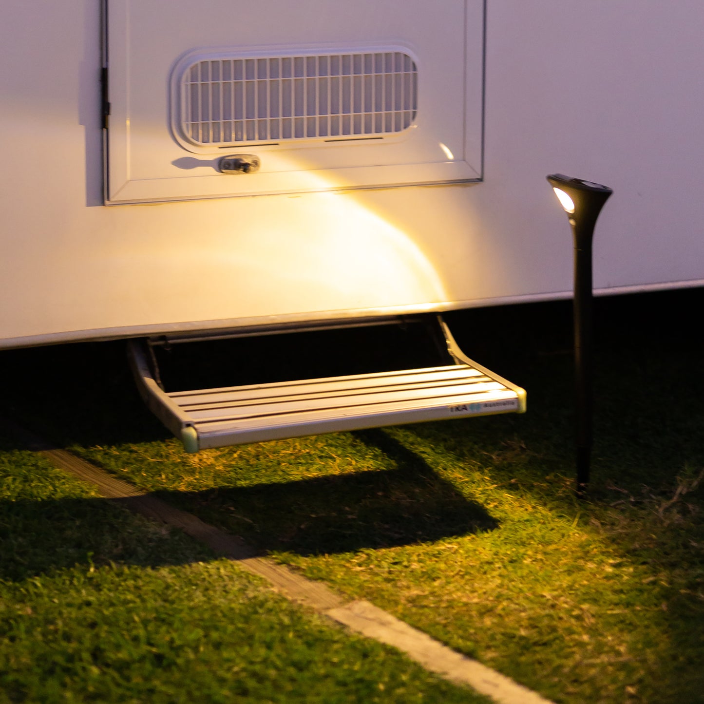 solar garden path light illuminates the step and entry to a mobile home
