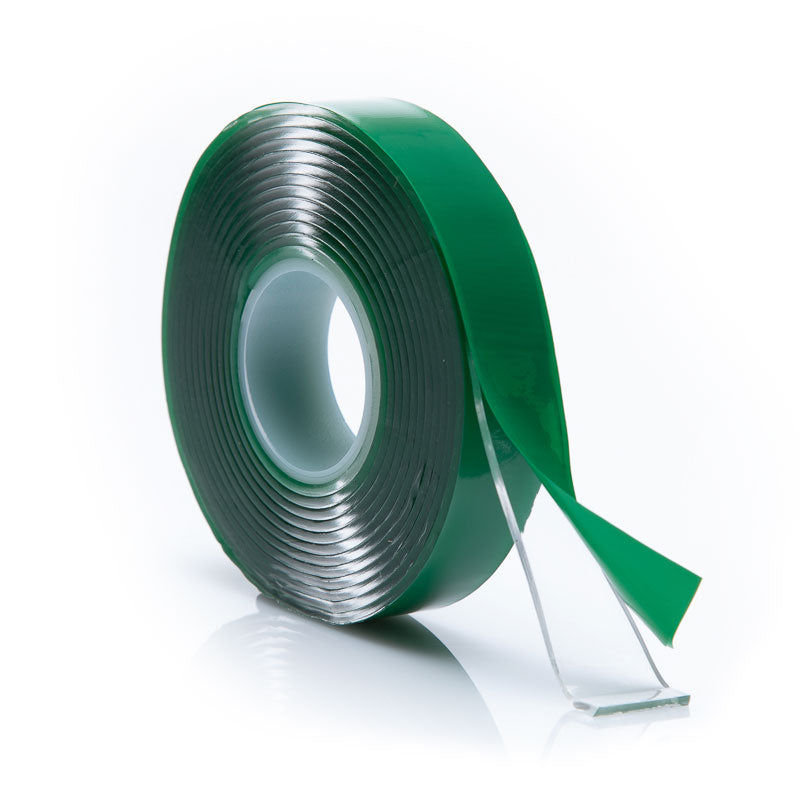 Double Sided tape with green protective film on a white background