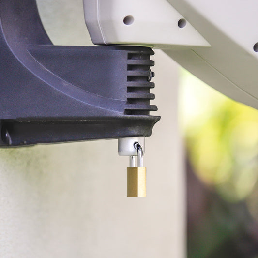 Close up image of a padlock in a hole of the hose reel pin at the underside of the wall bracket.