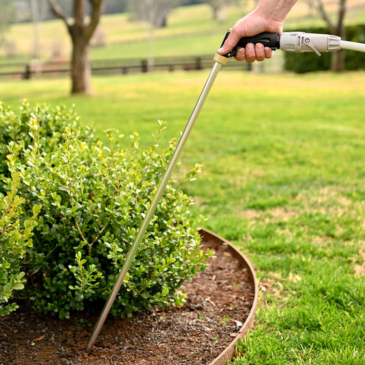 person breaking the soil in a large pot