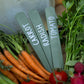 Set of three recycled plastic sage green plant labels in a basket of vegetables