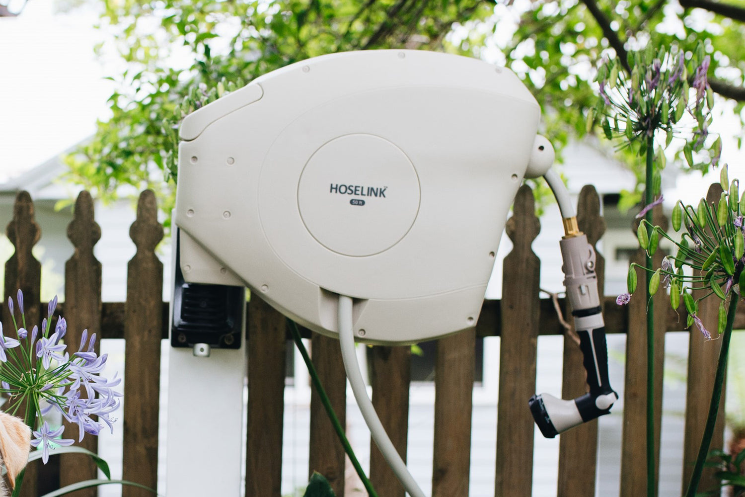 warm-gray-retractable-hose-reel-mounted-infront-of-wooden-fence