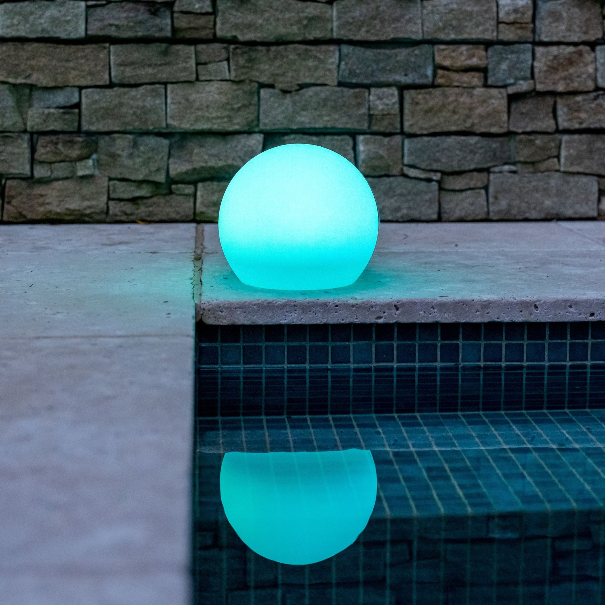 Glowing blue solar sphere light on a stone ledge with a stone wall background