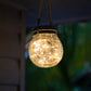 Solar crackle glass light turned on and hanging up on a veranda