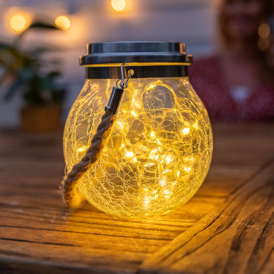 Solar crackle jar turned on and sitting on a wooden table