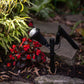 solar garden spot light illuminates a bush