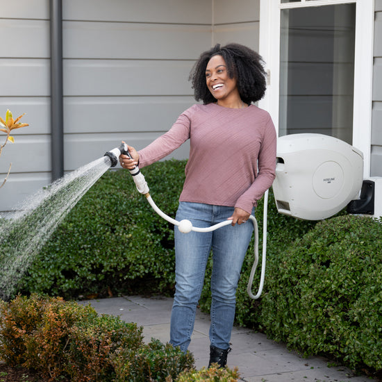 woman-watering-garden-with-beige-retractable-hose-reel