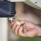 Image of a male hand holding the padlock and putting it into the hole of the hose reel pin.