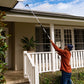 man cleaning gutter with long-reach pivot gutter cleaner