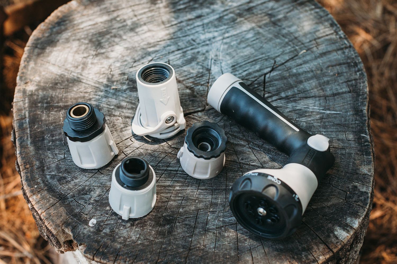 gray-spray-gun-with-four-hose-connectors-lying-on-a-wooden-board
