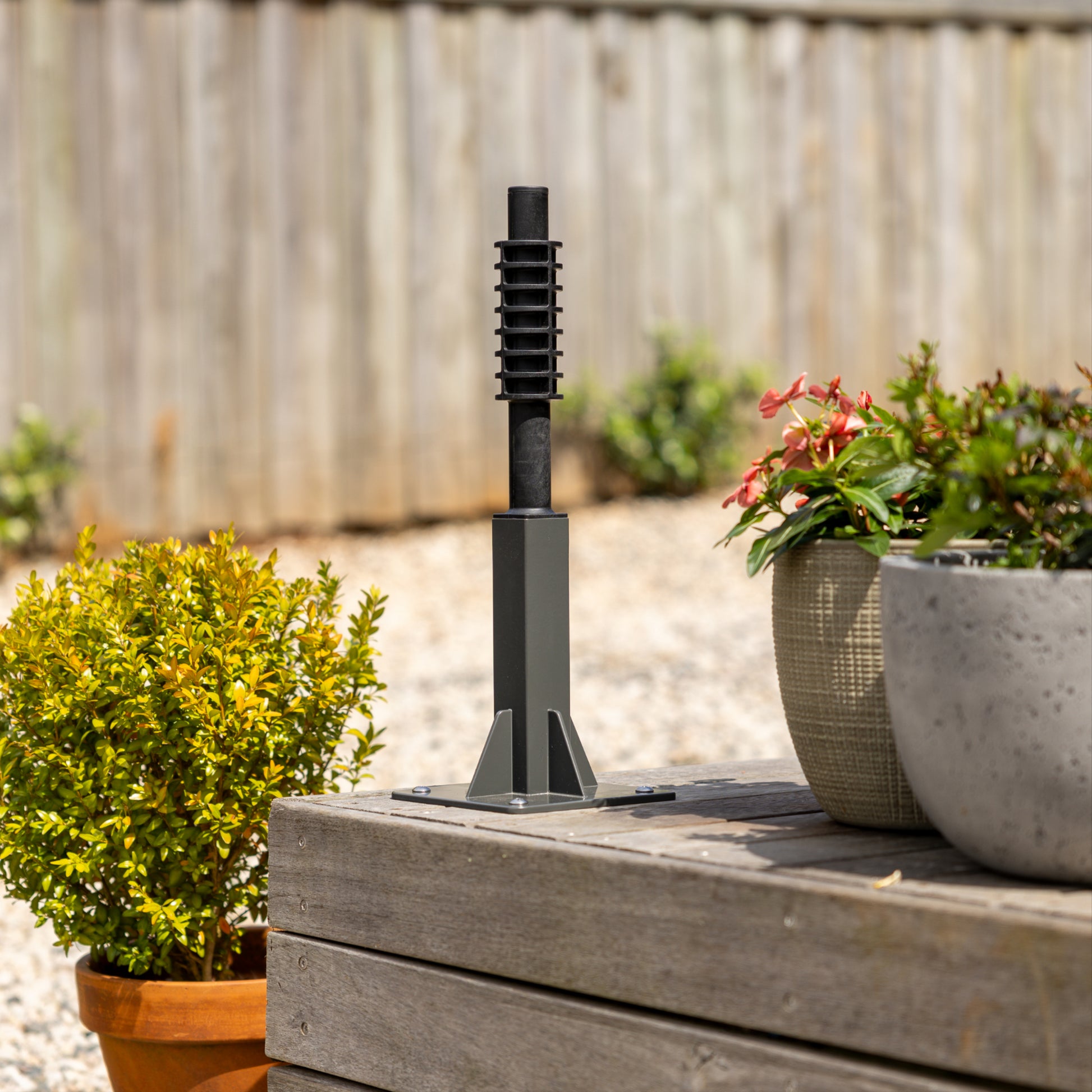 Ground Mount Evolve Series on a wooden deck with potted plants in the background
