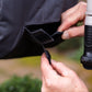 person attaching velcro tabs at front of charcoal evolve hose reel cover