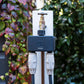 smart hose time dul outlet installed on an outdoor faucet on a white post with two hoses attahced