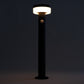 Black outdoor lamp post with illuminated light fixture against a dark background