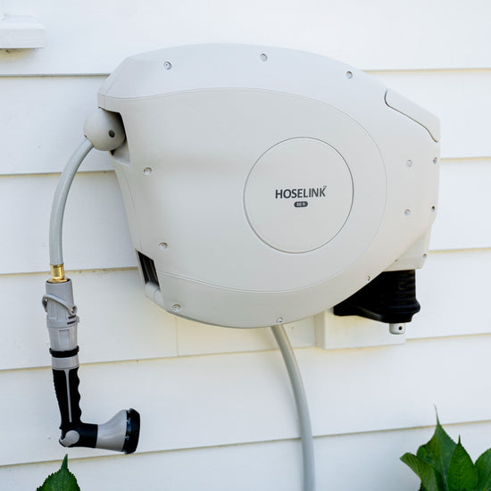 beige-retractable-hose-reel-against-white-weatherboard-home